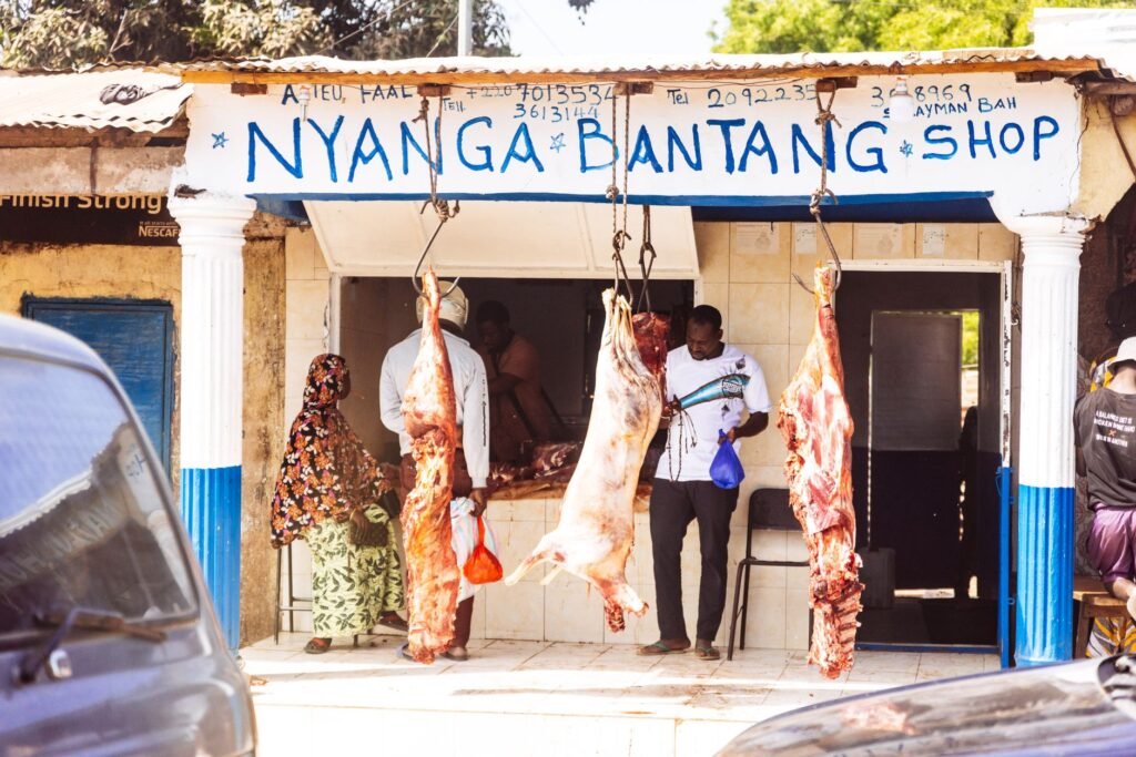 Traditional butcher shop with hanging meat display in a village setting, capturing local commerce.