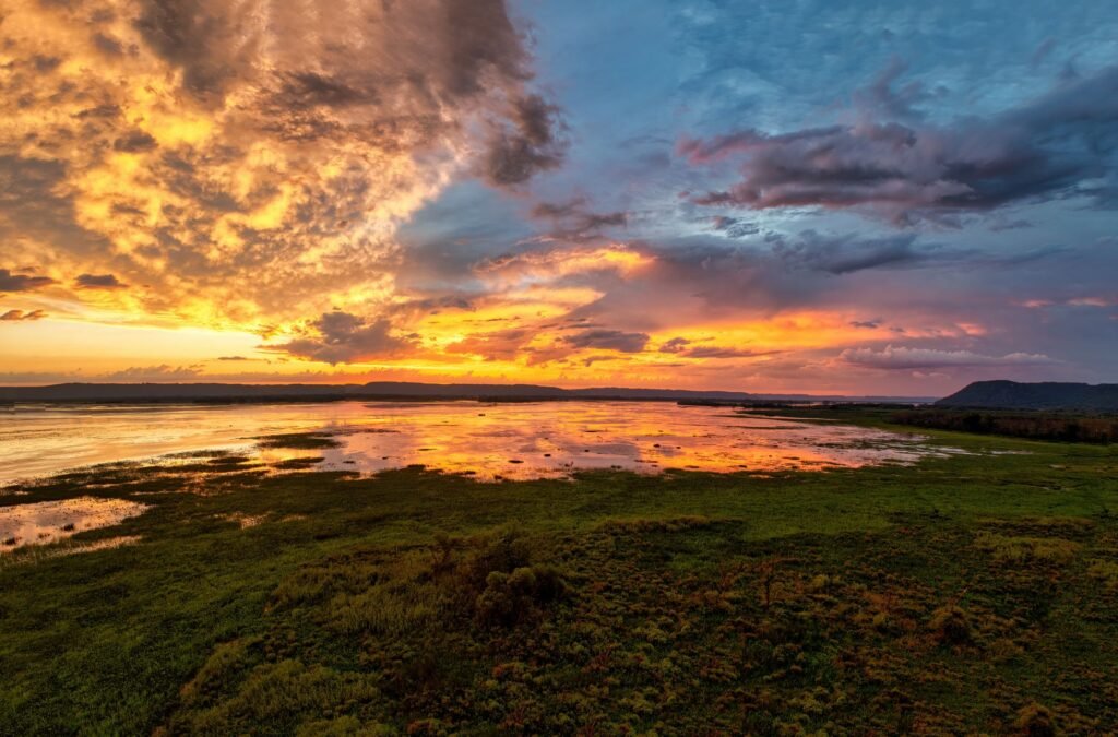 Captivating sunset over a wetland landscape in Weaver, MN, showcasing dramatic clouds and vivid reflections.