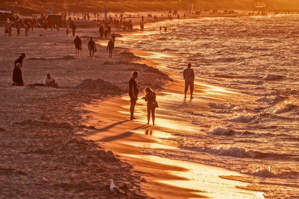 beach, vacation, golden hour, people, tourists, holiday, coast, sand, seashore, sea, ocean, wave, sunlight, sunset, sunshine,