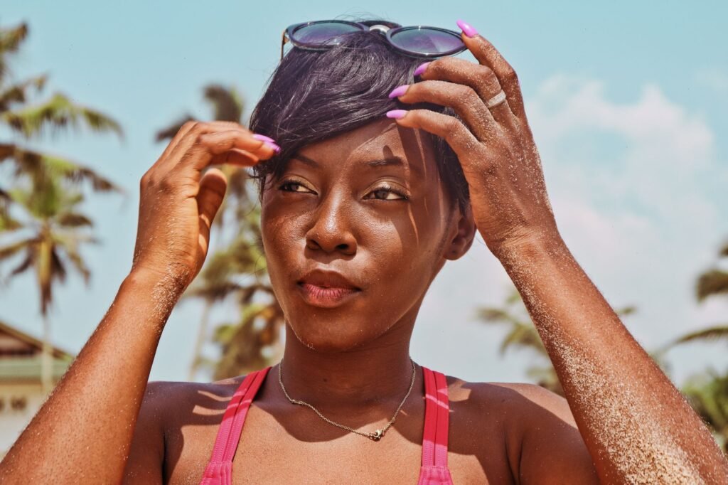 Portrait of a relaxed woman with sunglasses at a sunny tropical beach, enjoying the warm climate.