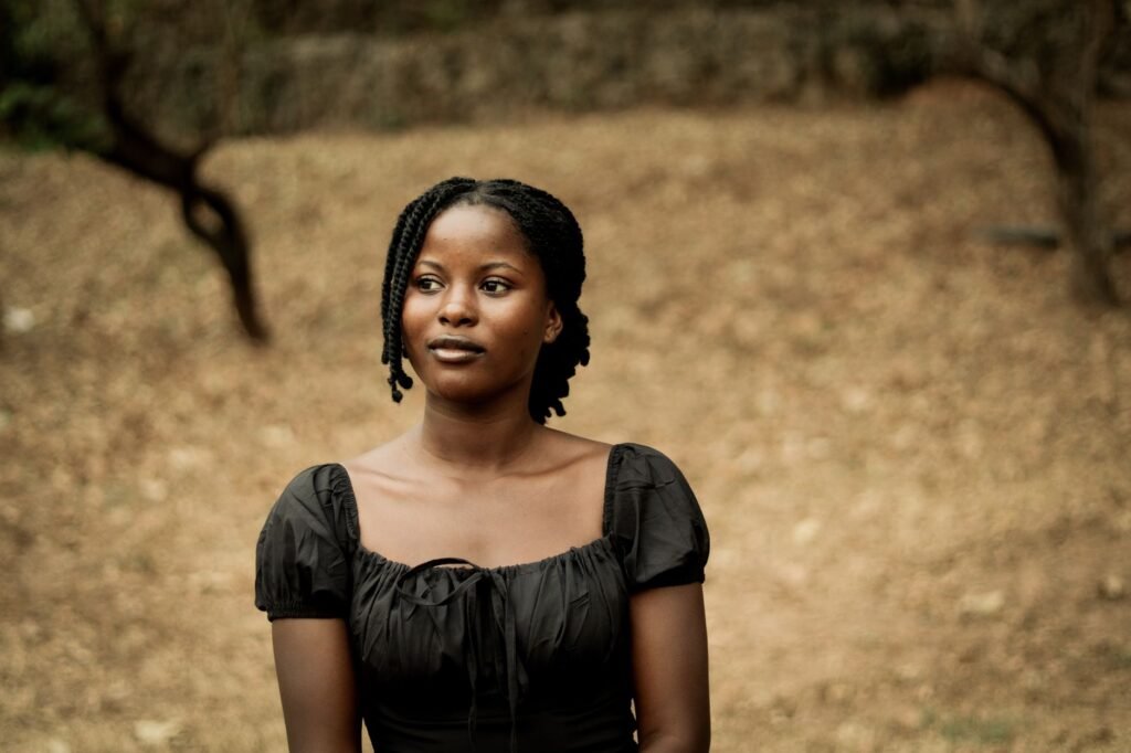 Portrait of a woman in a black dress outdoors, displaying elegance and calmness.