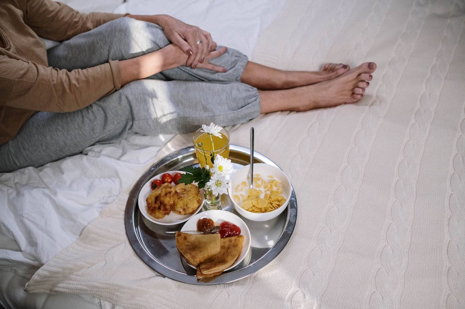 Cozy morning breakfast in bed featuring pancakes, fruit, and flowers. Perfect start to the day.