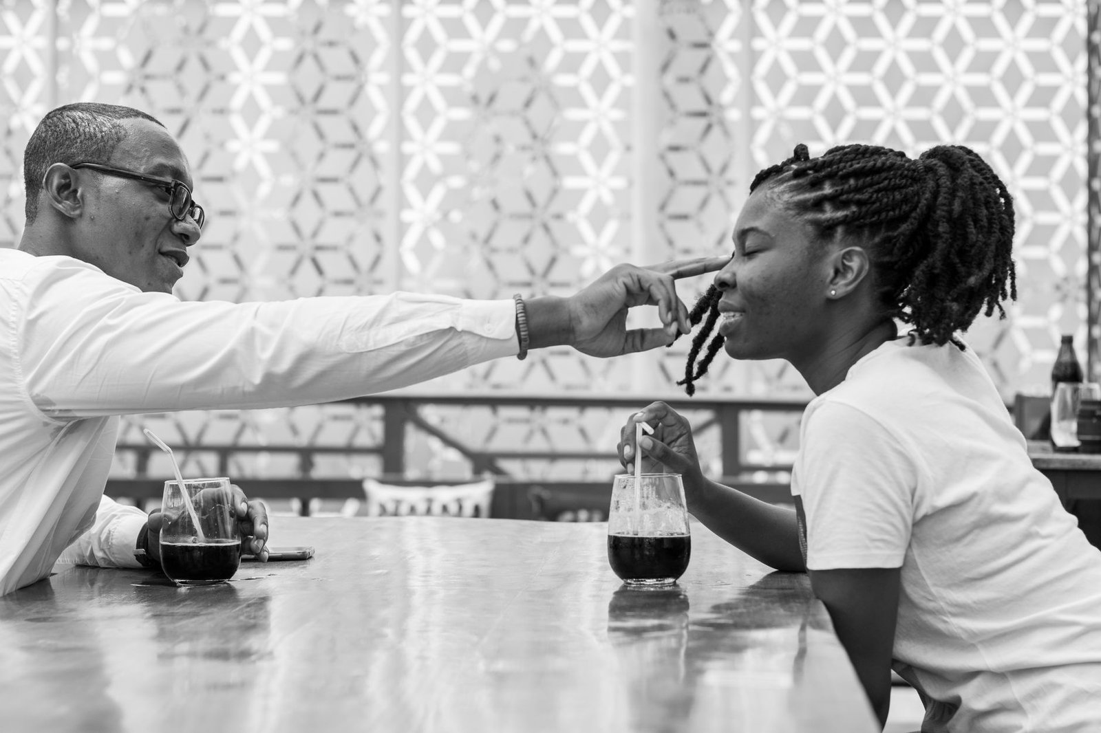 Black and white photo of an African couple enjoying drinks and conversation at a cafe in Accra, Ghana.