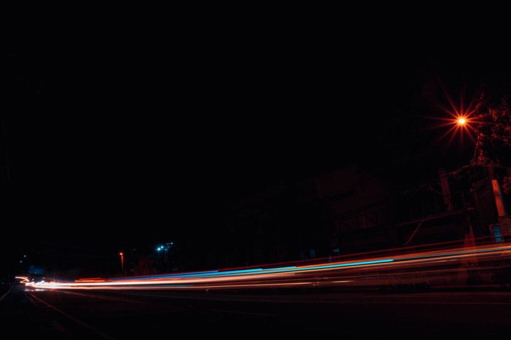 Colorful light trails create an artistic display in this nighttime street scene.