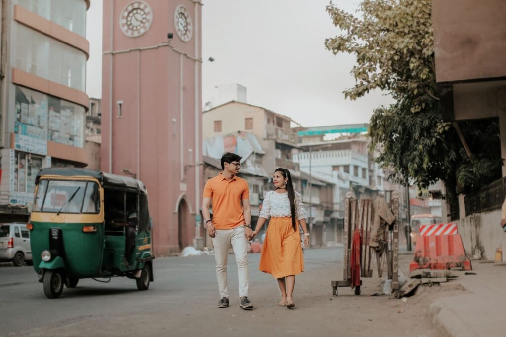 Young couple walking hand in hand through the urban streets of Surat, India.