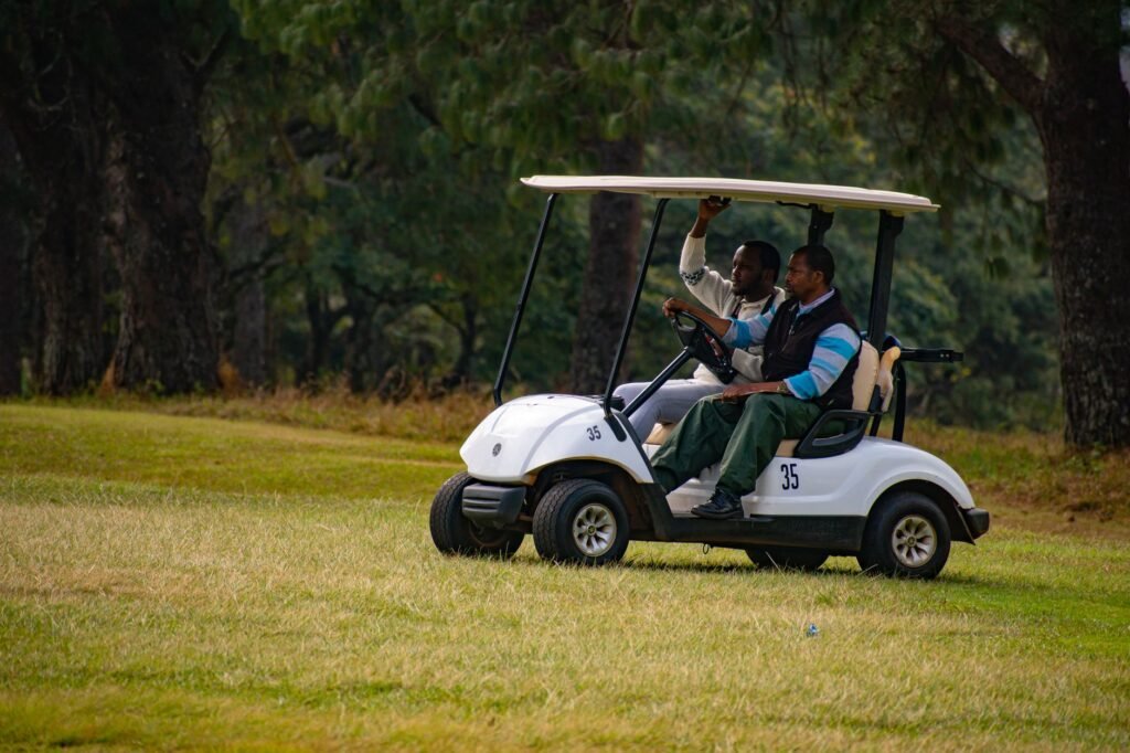 Two people enjoying golf cart ride through lush greenery of Piggs Peak, Eswatini.