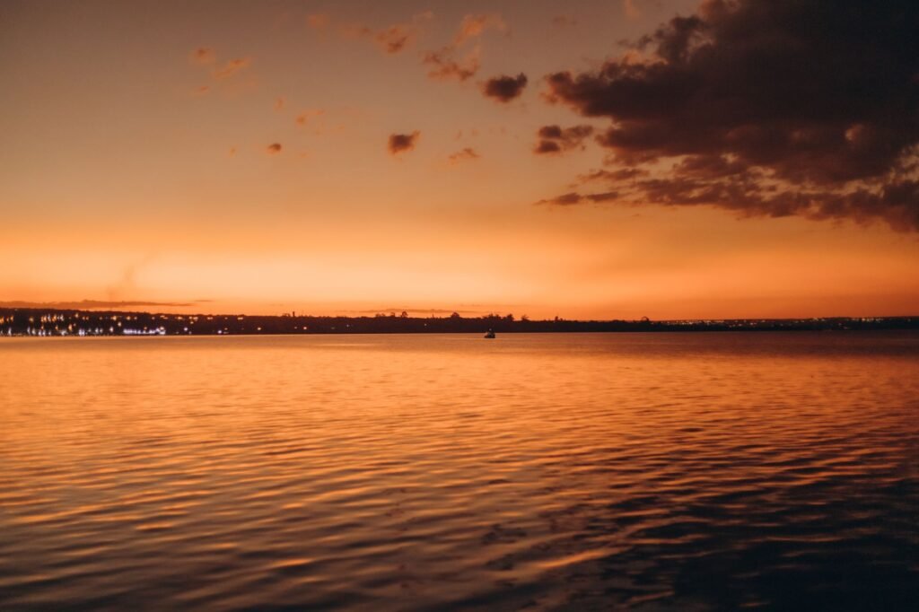 A breathtaking sunset with vibrant orange hues over a tranquil coastal sea view, perfect for nature lovers.