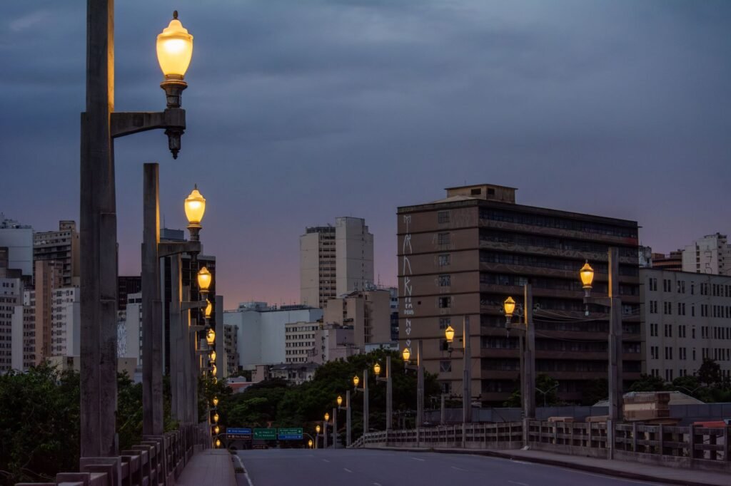 Street lamps illuminate a cityscape of Belo Horizonte, Brasil during twilight with a serene urban ambiance.