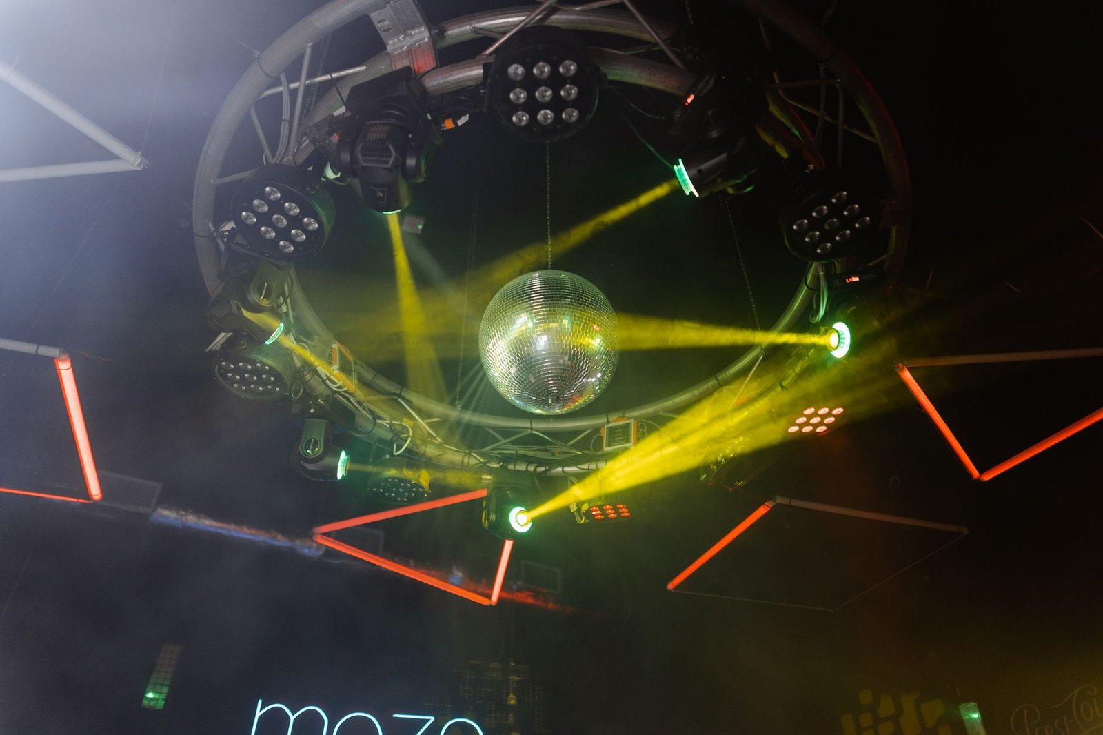 Dynamic disco ball with neon and strobe lights in a vibrant club setting.